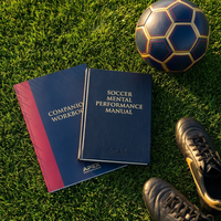 Soccer manual and workbook flat lay on a pitch